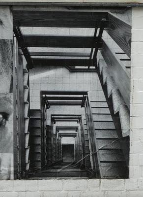 Top view of staircases going down; looks like a tunnel receding into distance.