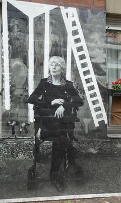 Seated woman wearing black jacket with striped collar.
