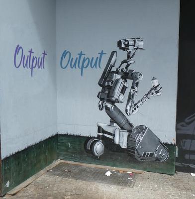 Word “output” spray-painted on wall by robot with a spray paint can.