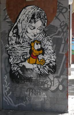 Black and white realistic woman in head scarf, cradling a puppy Pluto in her arms. The puppy is in color