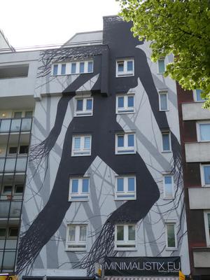 Large wall painting of silhouette of a woman with tree-branch-like fingers and feet