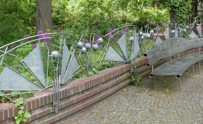 Fence with triangular panels and silver-colored spheres