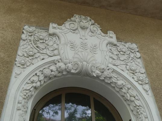 Ornate reliefwork above an arched window frame.