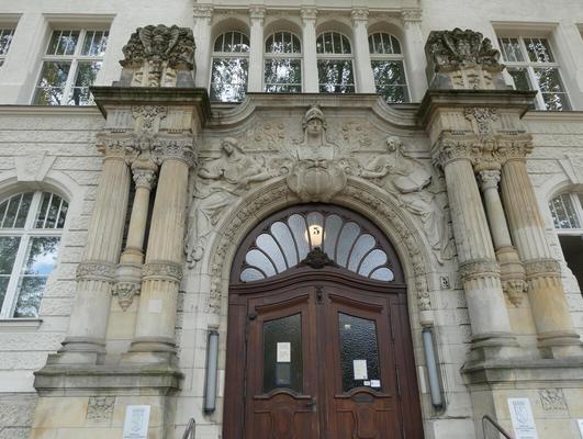 Arched doorway with ornate carvings above and two columns each to left and right