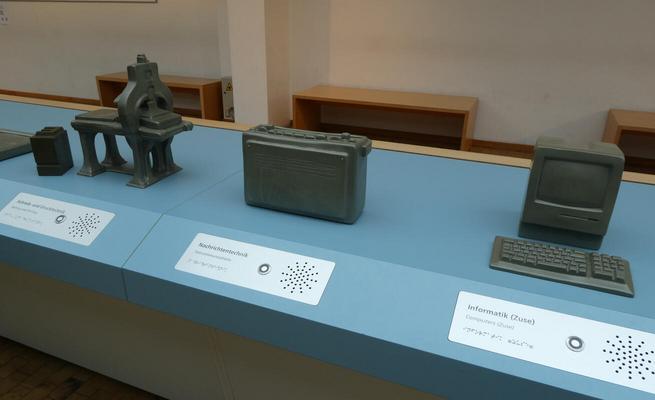 Model of several machines with braille markings on placards