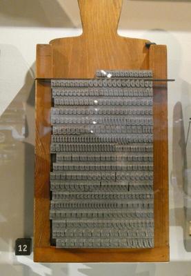 Wooden frame with several lines of metal type forms.