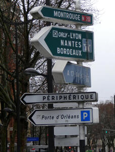 Arrow-shaped signs on street pointing in several different directions.