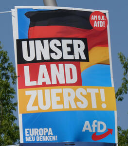 German flag in background; text: Unser Land zuerst!