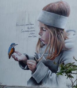 Little girl with bird perched on finger.