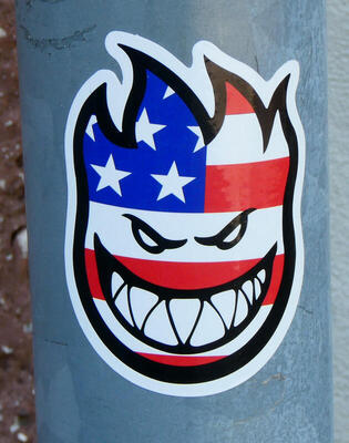 Demonic grinning face with American flag motif.