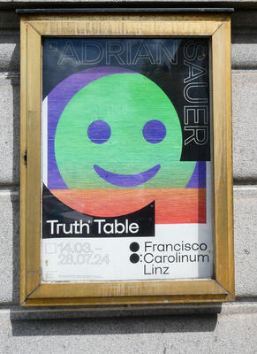 Poster with green smiley face for an art exhibition titled Truth Table.