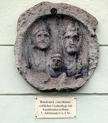 Ancient roman relief showing three people.