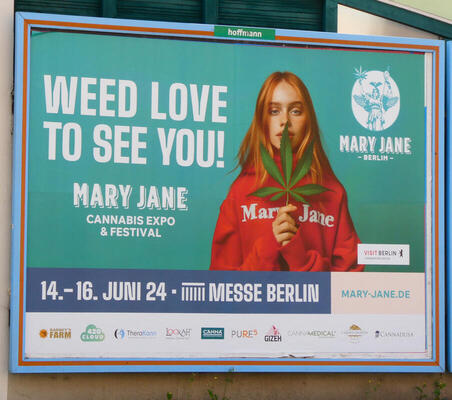 Weed Love to See You! / Mary Jane Cannabis Expo & Festival (Image shows woman holding marijuana plant leaf; she is wearing a hoodie labeled Mary Jane.