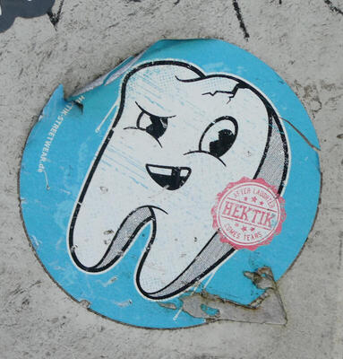 Cartoon tooth  with crack at top, sneering with a gap in its teeth