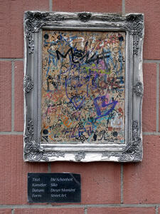 Elegant silver frame; the “canvas” is filled with graffiti.