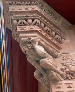 carved figure graoning while supporting cornice