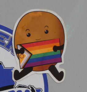 Cartoon figure holding a pride flag.