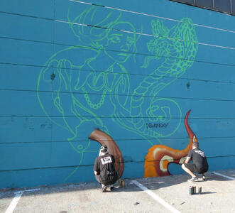 Artists working at base of a painting. Only that part is complete. The rest is the outline of a woman and a dragon.