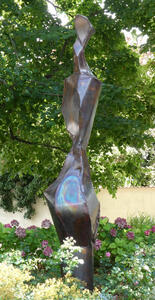 Abstract bronze sculpture. At bottom, a ring that looks like an oil sheen