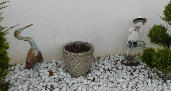 At left, metal crane (bird=. At right, a boy in tracht holding a wire basket