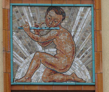 Mosaic of naked man playing flute. he is kneeling, with his genitals hidden.