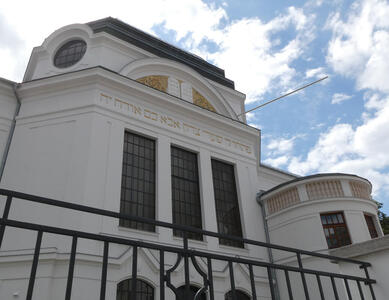 Synagogue with Hebrew words and the 10 commandments under an arched part of the facade.