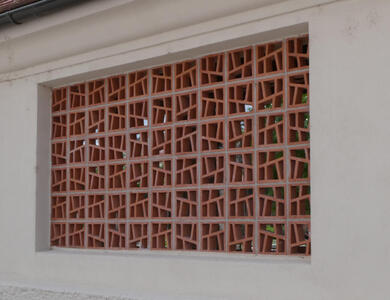 Opening in wall tiled with irregularly shaped geometric forms.
