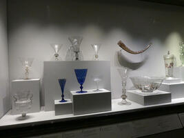 Various vase-like glasses in blue and clear glass, gold ale horn in background