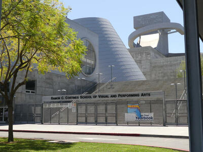 Front of school with angled cylindrical structure in background.