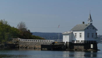 White lighthouse resembling an ordinary house with a church steeple