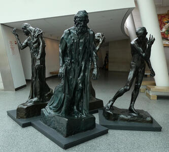 Four sculptures of men in a back-to-back square