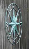 Patina'd bronze compass rose on wooden fence