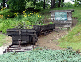 Replica of coal cars used as flower planters. Plaque nearby says it is a memorial to the coal miners who worked in the area.