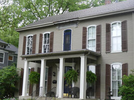 House with blue door on second floor that exits to first floor overhang rather than a balcony.