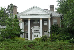 Large brown brick buildling with four white columns