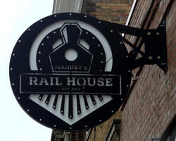 Sign for Maquet Rail House (restaurant) with logo in shape of the front of a locomotive.