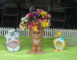 Whimsical pottery in shape of lamb, a grinning tree with feet, and a duck