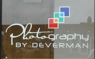 Sign for Photography by Deverman; “photo” is in cursive, “graphy” in a block sans-serif font