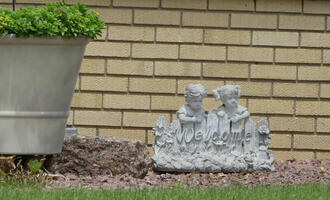 Small sculpture with word “Welcome” and a little girl and boy.