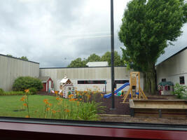 Outdoor child care area with slide and sandbox