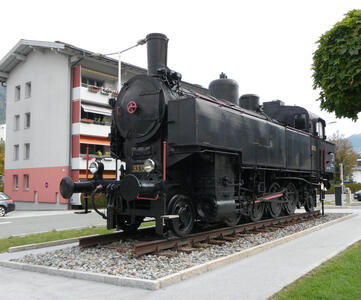 Old school black locomotive in front of train station