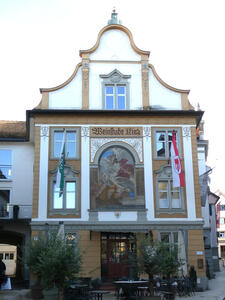 Old building housing a wine bar. There is a religious-themed fresco on the first floor above the entrance