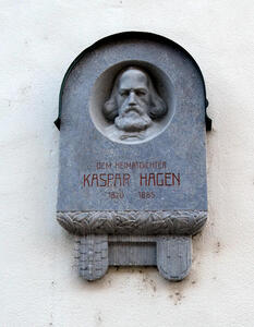 Plaque with relief of bearded man. Text: Dem Heimatdichter Kaspar Hagen 1820-1865
