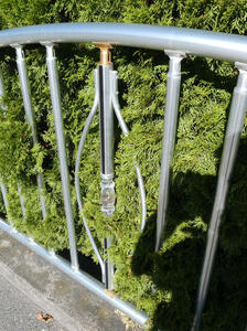 Metal fence with vertical bars. One bar has a glass portion in it.