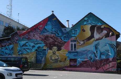 Wall painting on side of building with a couple of human figures