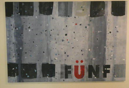 Gray background, text FÜNF 5 the Ü is in red