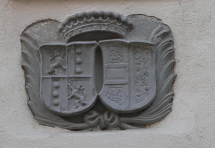 Relief sculpture of two coats of arms with a crown above.
