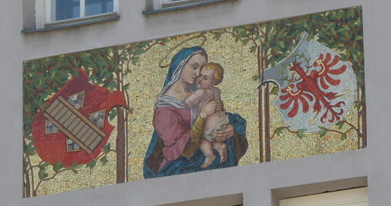 Mosaic of Madonna and child; trees and heraldic shields at left and right.