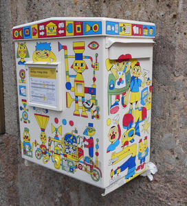 Mail deposit box with cartoonish characters in bright primary colours