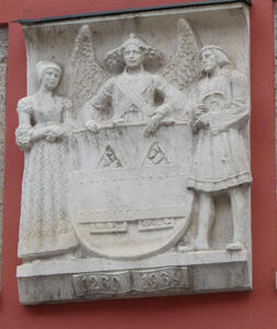 Angel holding a coat of arms. At left, a woman; at right, a man.